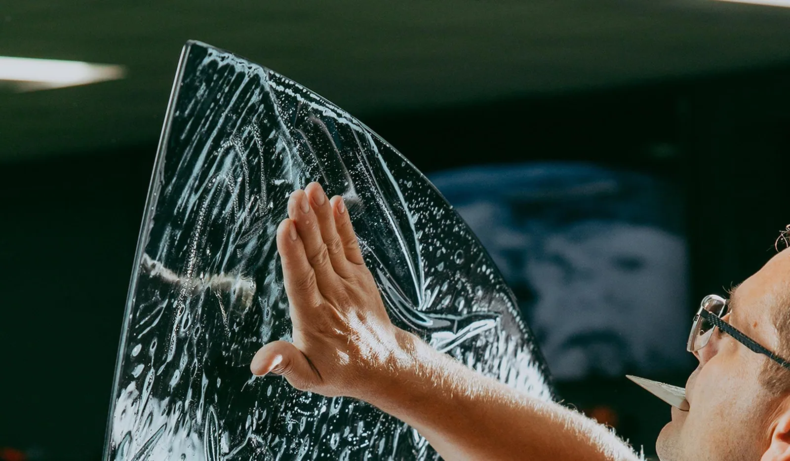 Installer shaping window tint film on glass