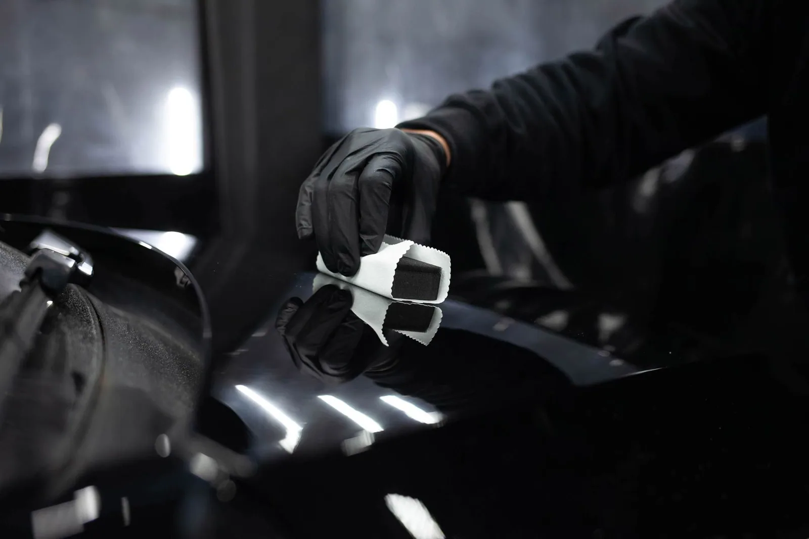 Ceramic coating being applied to a black car