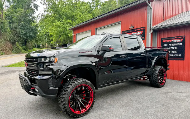 A black Chevrolet Silverado after an exterior detail, outside the shop