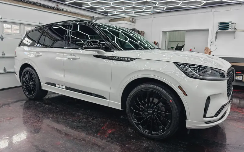 A white Lincoln Aviator with a gloss-black piano-top wrap
